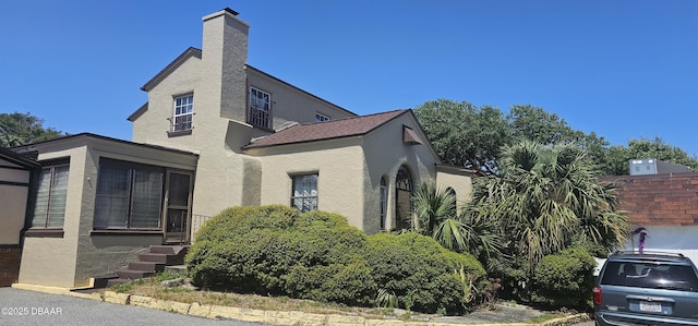 view of home's exterior featuring a chimney and stucco siding