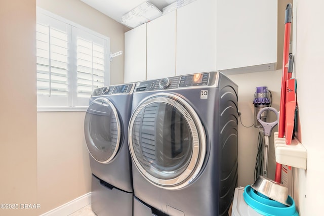 clothes washing area with cabinets and washer and dryer