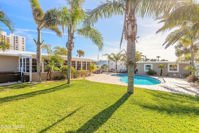 view of pool featuring a patio area, a sunroom, and a lawn