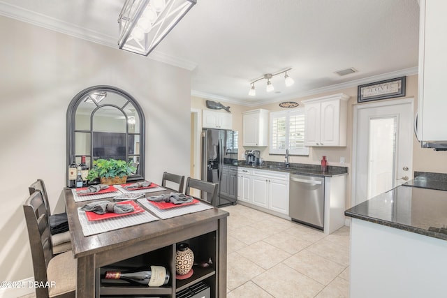 kitchen featuring sink, white cabinets, ornamental molding, light tile patterned floors, and stainless steel appliances