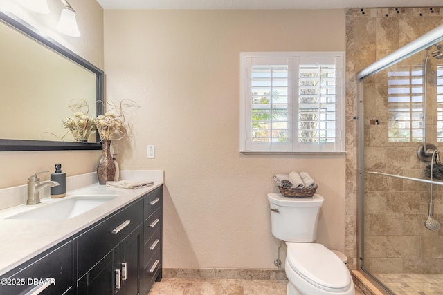 bathroom featuring vanity, a shower with shower door, tile patterned floors, and toilet