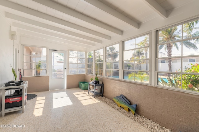 sunroom / solarium with beam ceiling and a healthy amount of sunlight