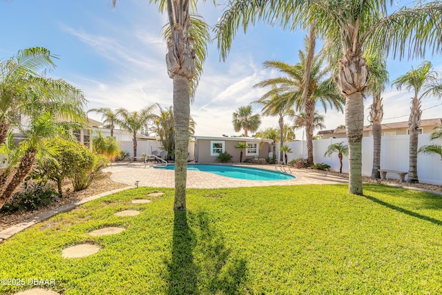 view of pool with a patio and a lawn