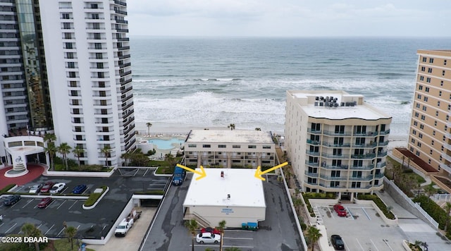 drone / aerial view with a water view and a beach view