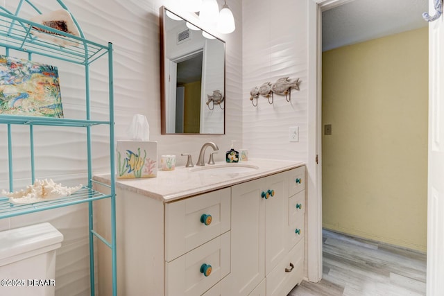 bathroom featuring hardwood / wood-style floors, vanity, and toilet