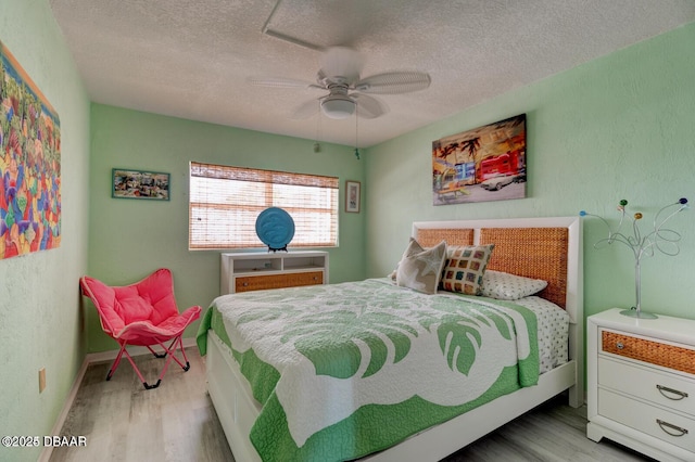 bedroom featuring a textured ceiling, light hardwood / wood-style floors, and ceiling fan