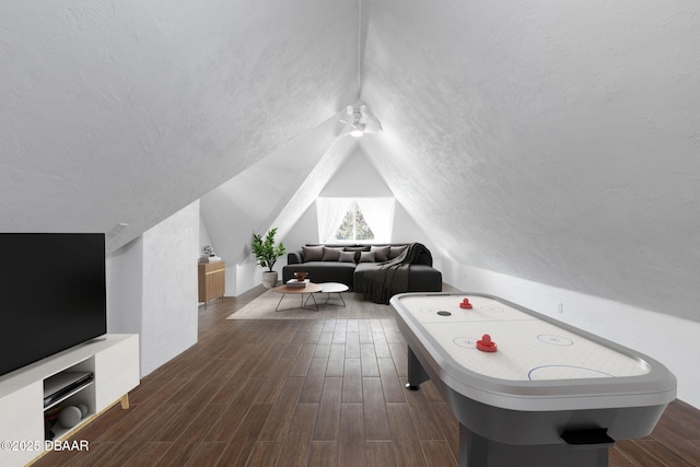 playroom with lofted ceiling, dark wood-type flooring, and a textured ceiling