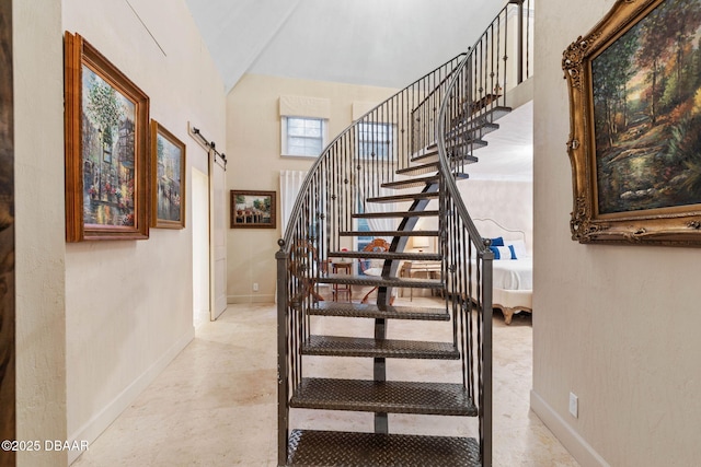 stairway featuring vaulted ceiling and a barn door