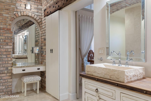 bathroom with brick wall and vanity