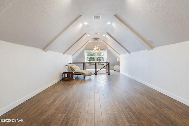 additional living space featuring lofted ceiling, dark hardwood / wood-style flooring, a chandelier, and a textured ceiling