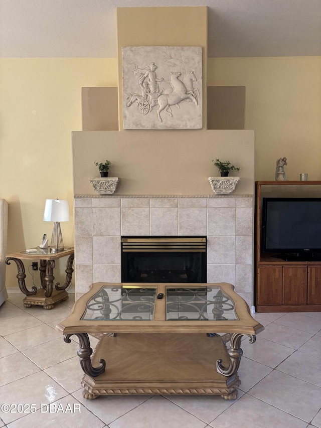 living area with a tiled fireplace and light tile patterned flooring