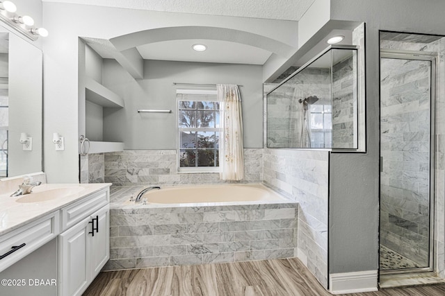 bathroom featuring vanity, separate shower and tub, and a textured ceiling