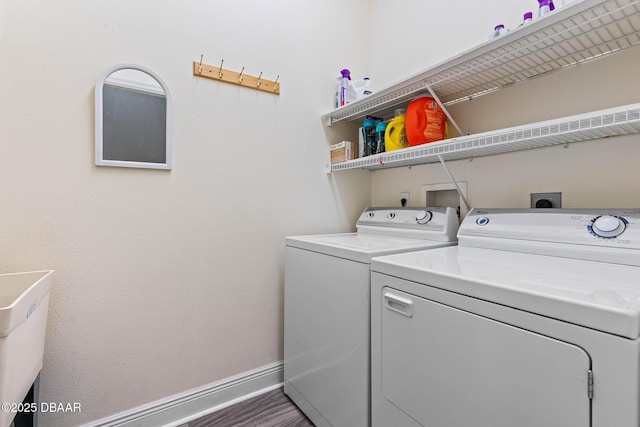 clothes washing area with dark hardwood / wood-style flooring and washing machine and dryer