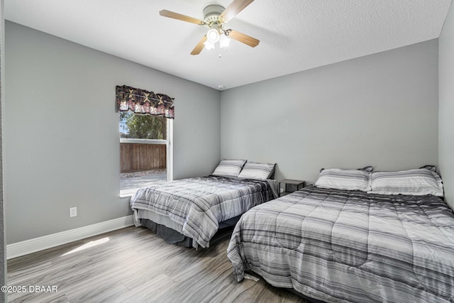 bedroom featuring hardwood / wood-style floors, a textured ceiling, and ceiling fan