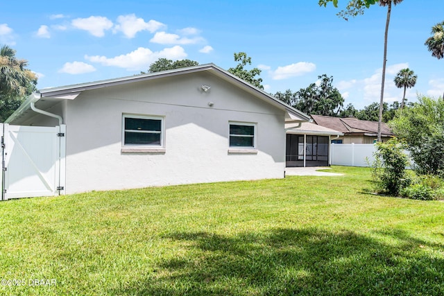 59 Blakeport Ln, Palm Coast, FL 32137 - rear view of property featuring a sunroom, a gate, and stucco siding