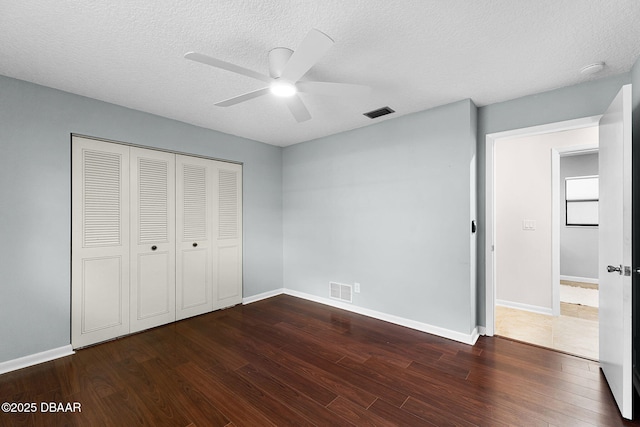 59 Blakeport Ln, Palm Coast, FL 32137 - unfurnished bedroom with dark wood-type flooring, a closet, ceiling fan, and a textured ceiling
