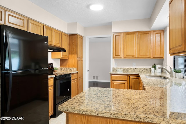 59 Blakeport Ln, Palm Coast, FL 32137 - kitchen featuring black appliances, under cabinet range hood, light stone countertops, a textured ceiling, and a peninsula