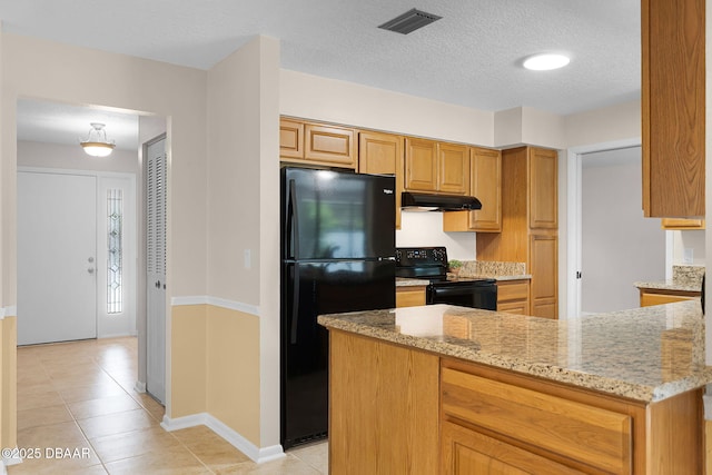 59 Blakeport Ln, Palm Coast, FL 32137 - kitchen featuring black appliances, under cabinet range hood, light stone countertops, light tile patterned flooring, and a textured ceiling