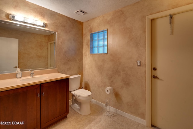 bathroom with vanity, tile patterned flooring, a textured ceiling, and toilet