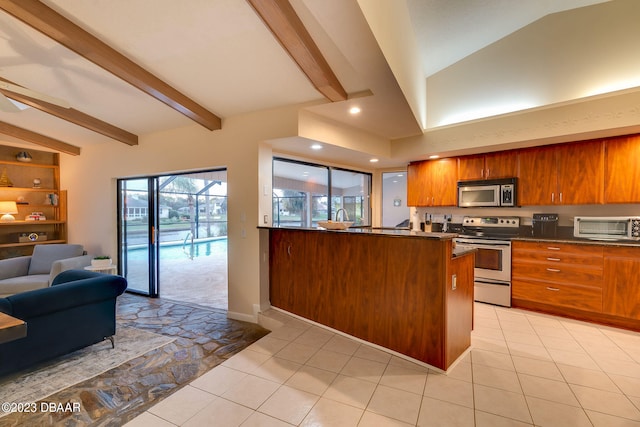 kitchen with stainless steel appliances, light tile patterned floors, vaulted ceiling with beams, and kitchen peninsula