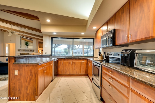 kitchen with stainless steel appliances, dark stone countertops, vaulted ceiling with beams, and kitchen peninsula