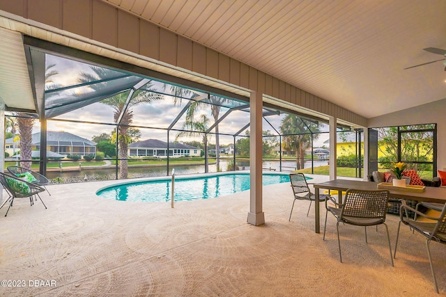 view of pool featuring a water view, glass enclosure, ceiling fan, and a patio area