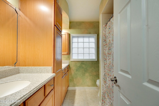 bathroom with toilet, vanity, and tile patterned floors