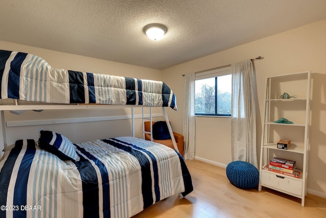 bedroom featuring light hardwood / wood-style floors and a textured ceiling