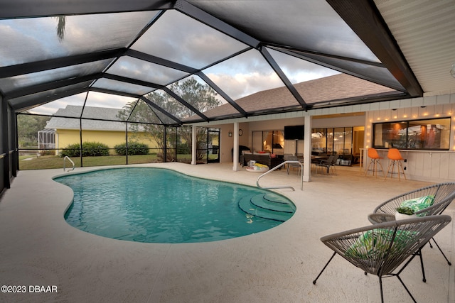 view of pool featuring glass enclosure and a patio area