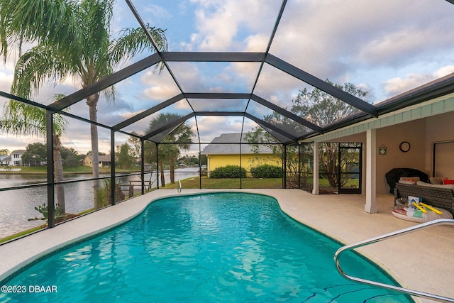 view of swimming pool with a patio, a water view, and a lanai