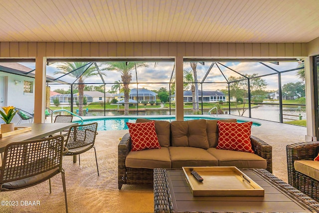 sunroom featuring a swimming pool, a water view, and a healthy amount of sunlight