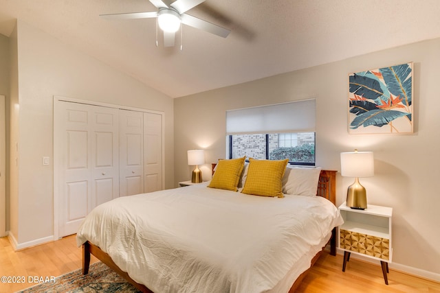 bedroom featuring wood-type flooring, ceiling fan, vaulted ceiling, and a closet