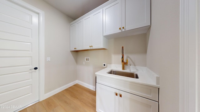 washroom with cabinets, sink, hookup for a washing machine, hookup for an electric dryer, and light hardwood / wood-style floors