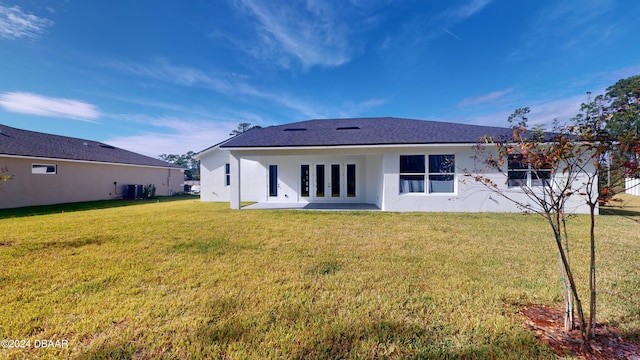 rear view of house with french doors, a patio, central AC, and a lawn