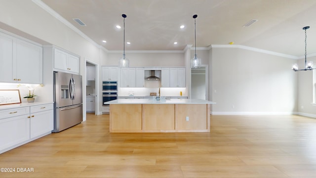 kitchen featuring stainless steel appliances, a spacious island, wall chimney range hood, white cabinetry, and hanging light fixtures