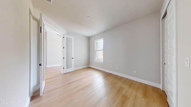 unfurnished bedroom featuring light hardwood / wood-style floors and a textured ceiling