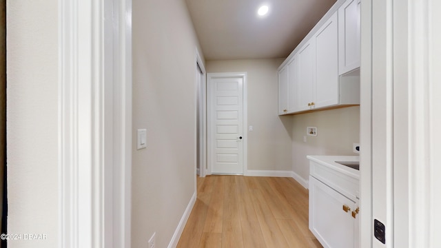 washroom featuring light hardwood / wood-style floors, cabinets, and hookup for a washing machine