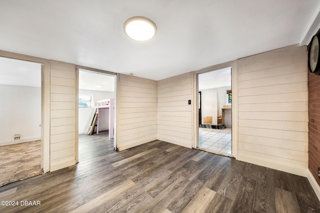 unfurnished room featuring wood-type flooring and wood walls