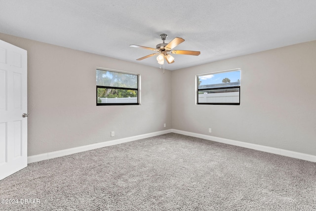 carpeted spare room with ceiling fan and a textured ceiling