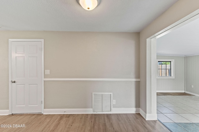 empty room featuring light hardwood / wood-style floors and a textured ceiling