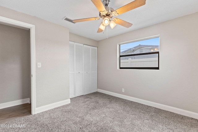 unfurnished bedroom with carpet flooring, ceiling fan, and a closet