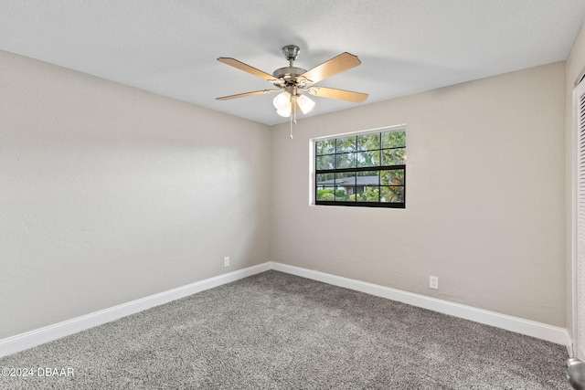 carpeted spare room with ceiling fan