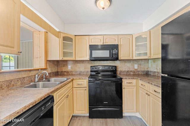 kitchen with sink, light brown cabinets, backsplash, black appliances, and light wood-type flooring