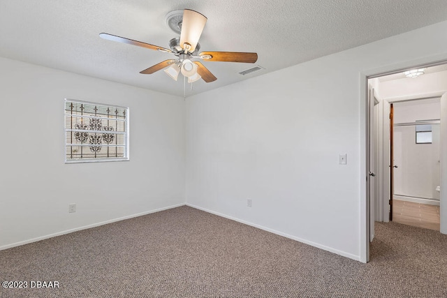 carpeted empty room featuring ceiling fan and a textured ceiling