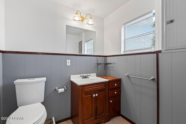 bathroom featuring vanity, a textured ceiling, and toilet