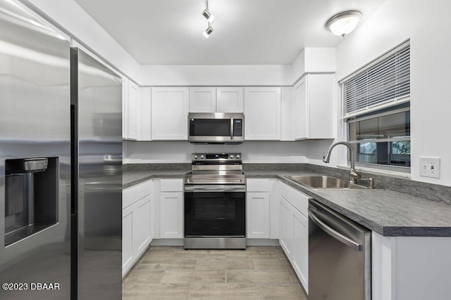 kitchen featuring sink, white cabinetry, stainless steel appliances, and light wood-type flooring