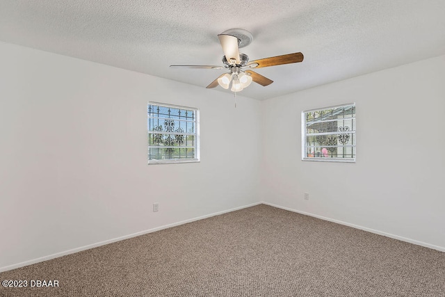 empty room with carpet flooring, ceiling fan, a textured ceiling, and a wealth of natural light