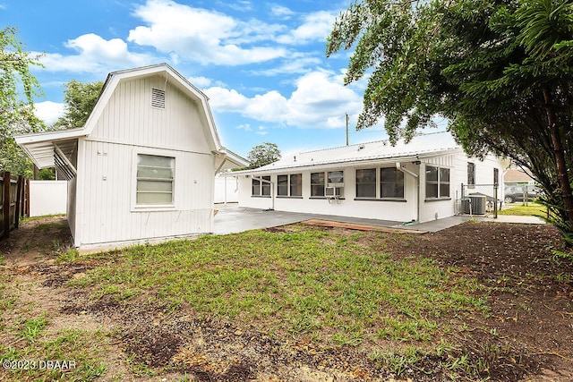 back of house featuring cooling unit, a patio area, and a yard