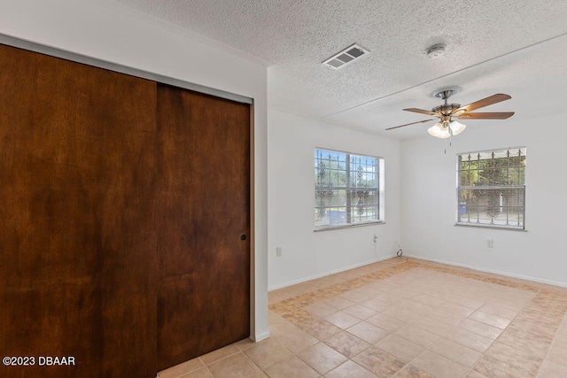 interior space featuring ceiling fan and a textured ceiling