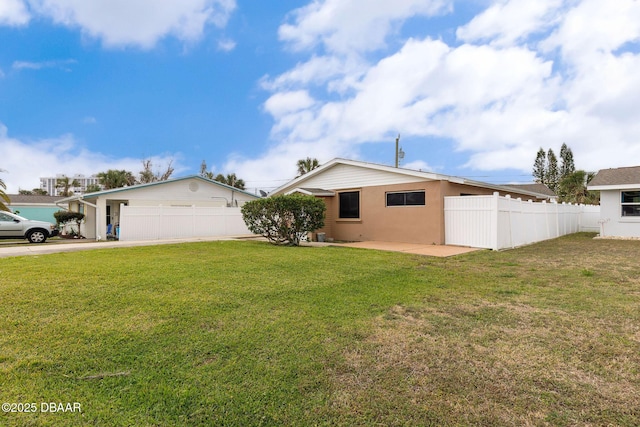 exterior space with a front yard, stucco siding, fence, and a patio